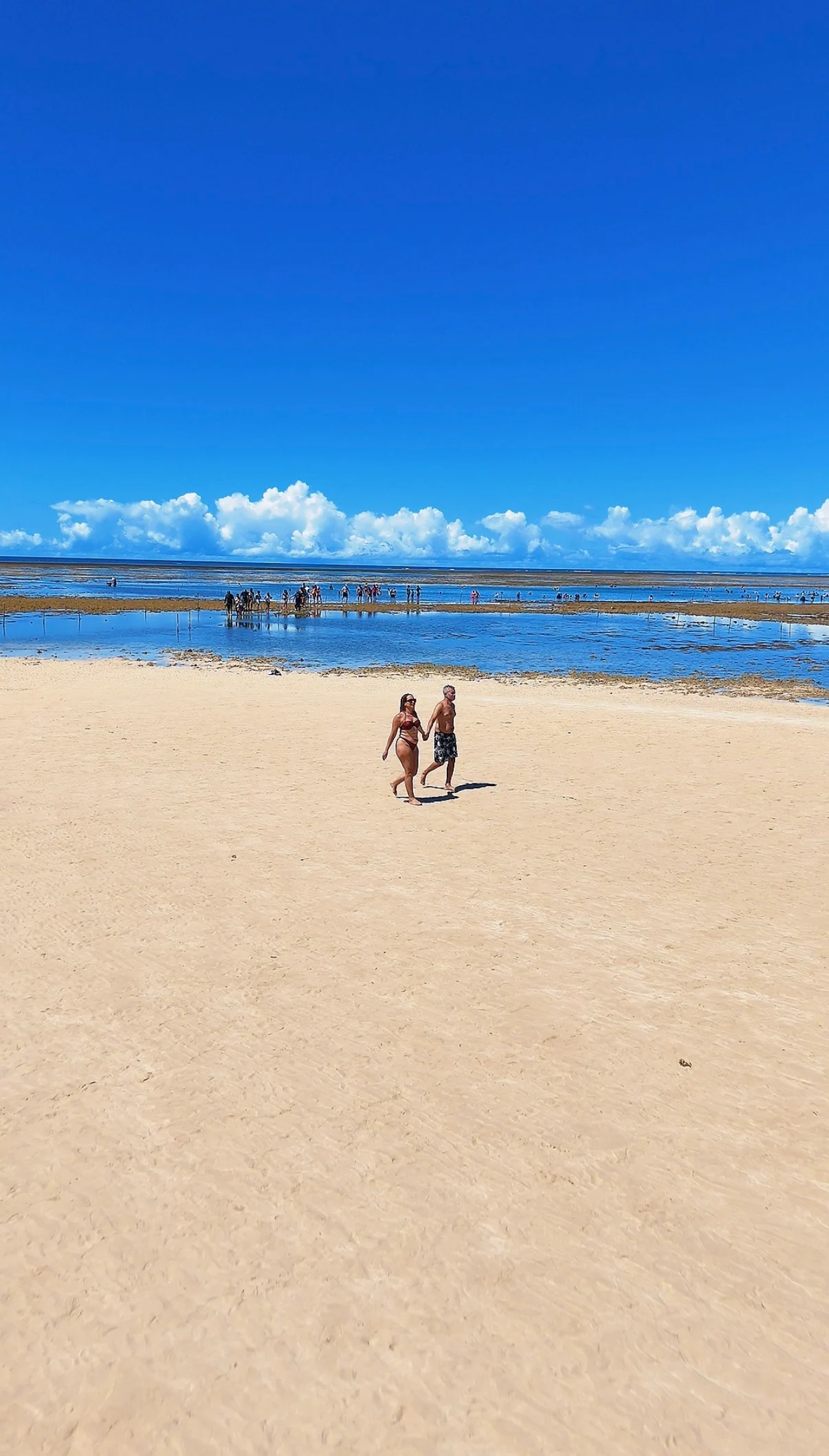 Casal caminhando pelo banco de areia em Recife de Fora