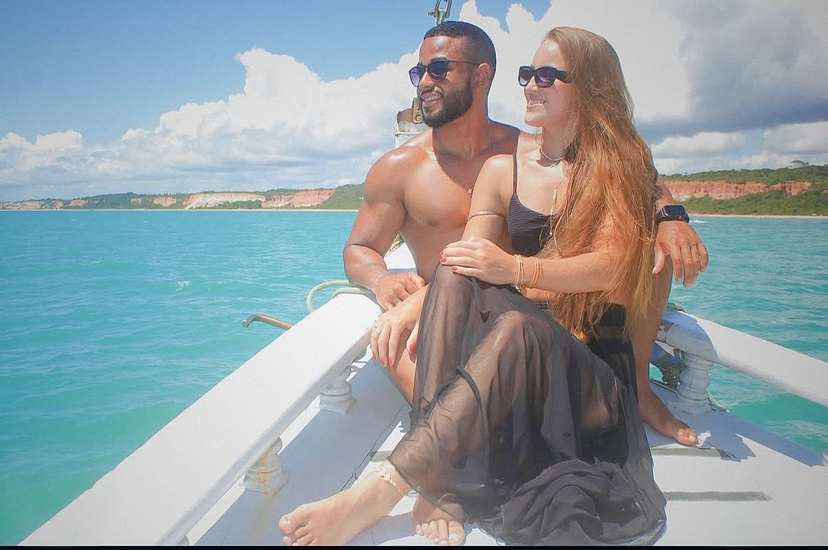 Casal no convés com o litoral de Trancoso ao fundo